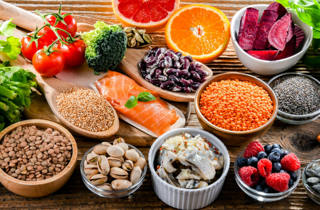 a selection of foods to promote healthy aging like salmon, lentils, beets, oranges, fruits, nuts and more