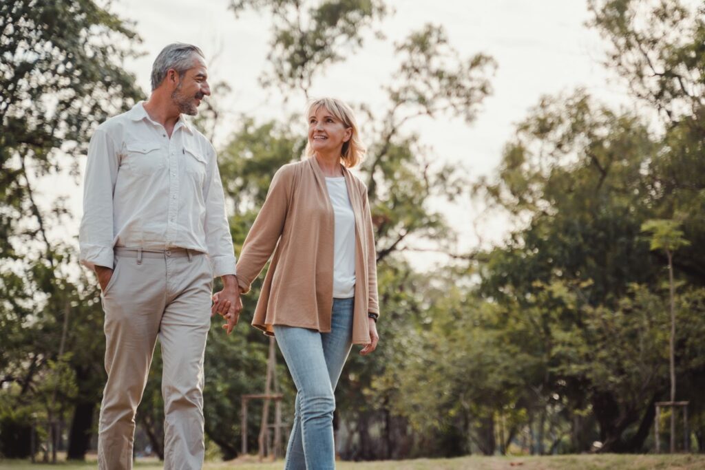 A senior couple walking together and holding hands.